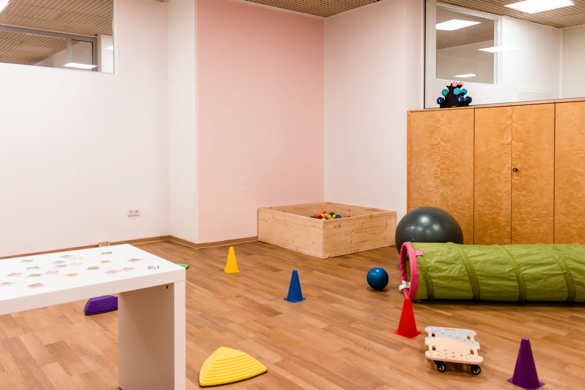 Helles Ergotherapie-Kinderzimmer mit Bällebad und Spielgeräten